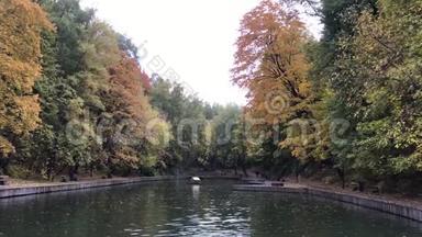 秋天的公园里有五颜六色的叶子和公园里的一个池塘。 秋<strong>天池</strong>塘的全景。